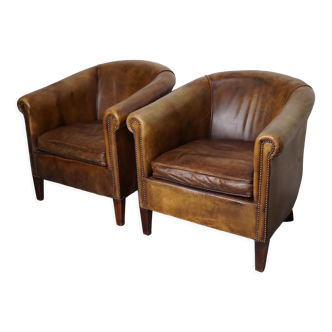 2 fauteuils club en cuir de couleur marron