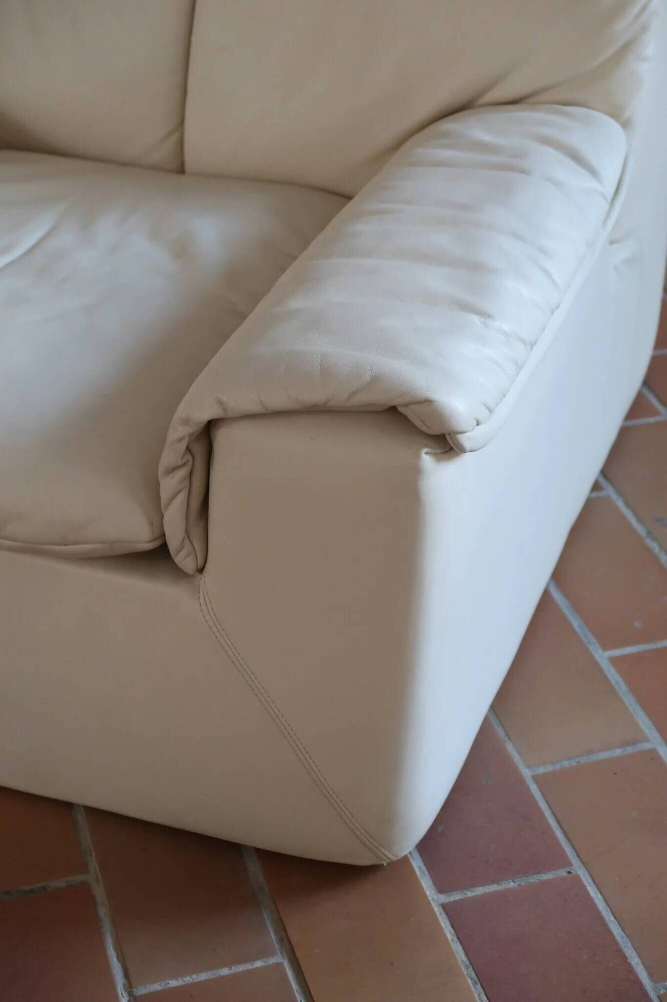 Cinna armchair in cream leather, bolstered armrests, 1970s.