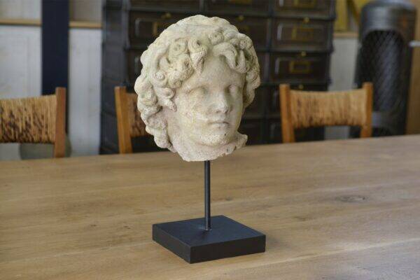 Sculpture of a head in reconstituted stone carved in the antique style of the 19th century