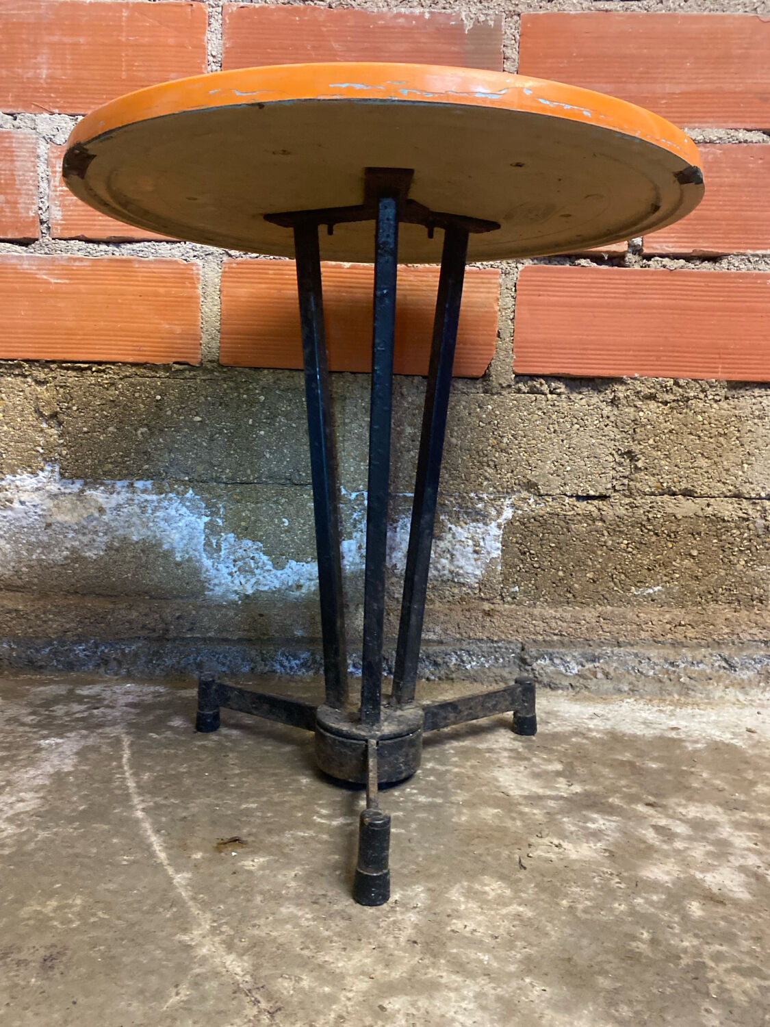Vintage bistro table with black cast iron base and orange bakelite top, 1950s