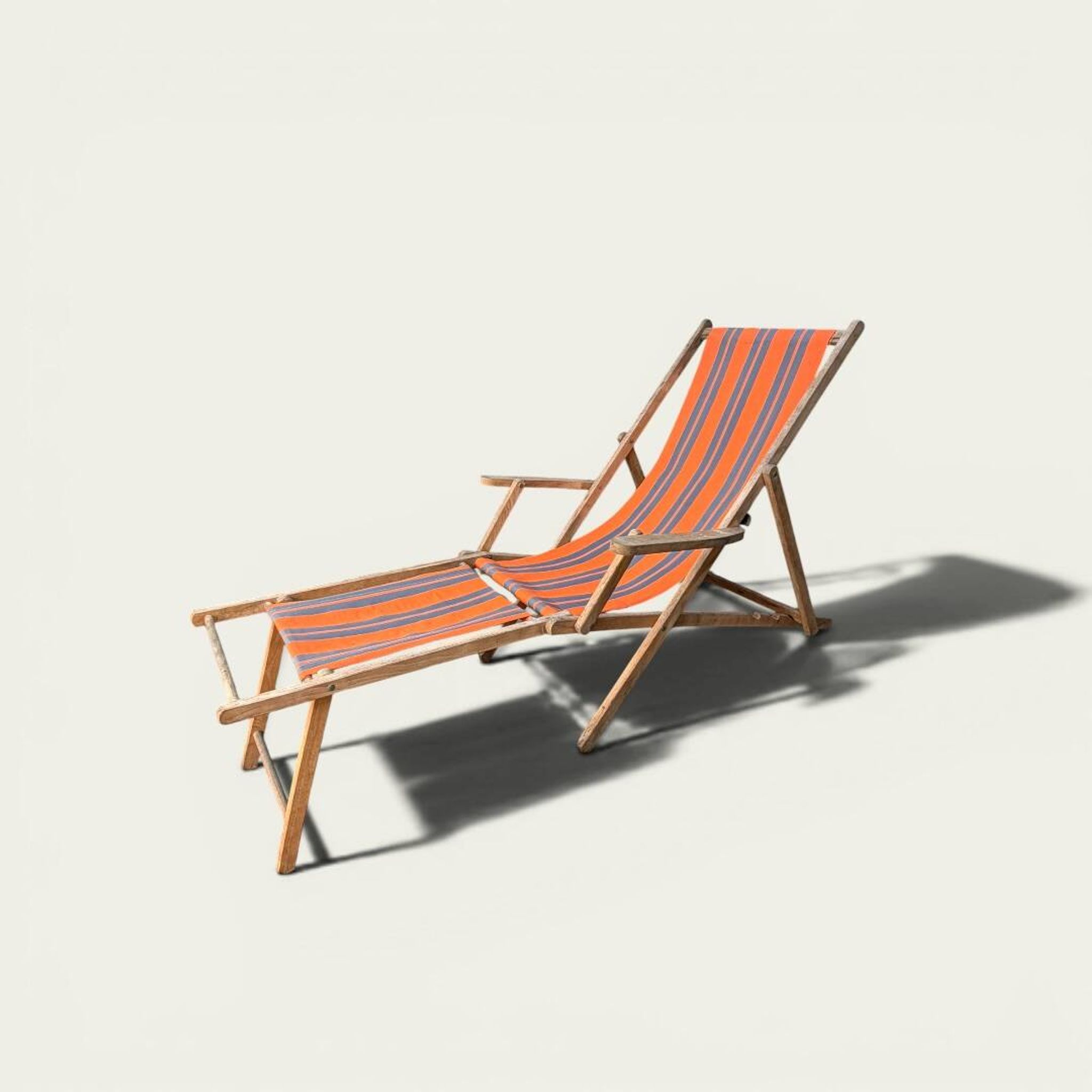 Vintage deck chair with orange and grey striped fabric, original patina.