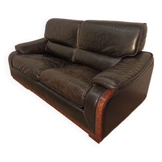 Black leather sofa and wooden armrests
