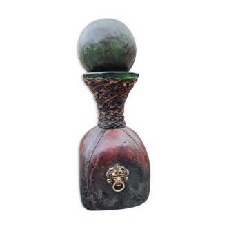 Vintage leather-covered bottle or decanter decorated with a lion's head