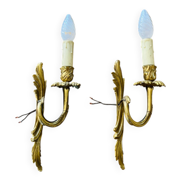 Bronze wall lights in the Louis XV style with curved branches and leaf decorations.