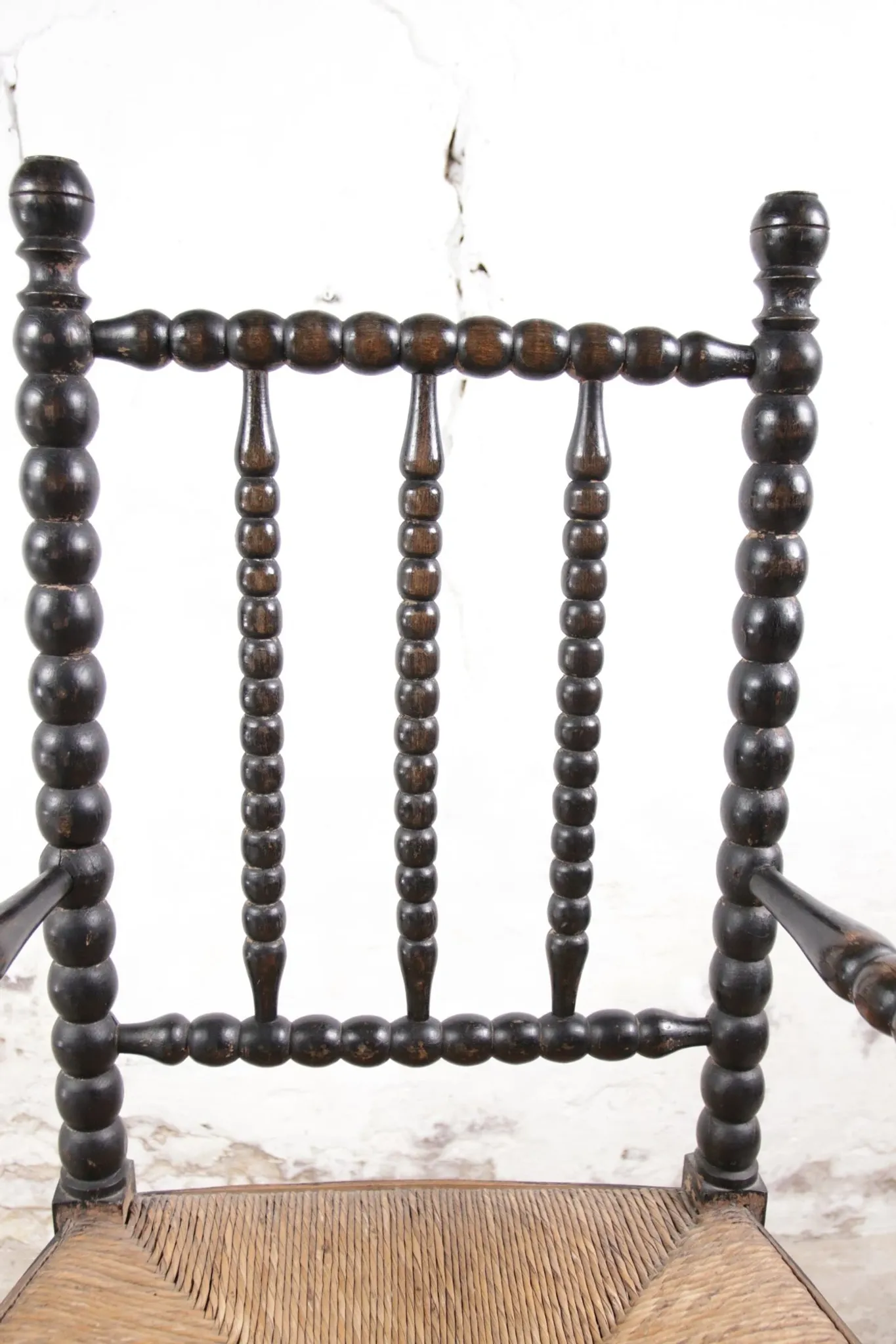 Black bobbin chair with armrests and rush seat – ca. 1900-1930