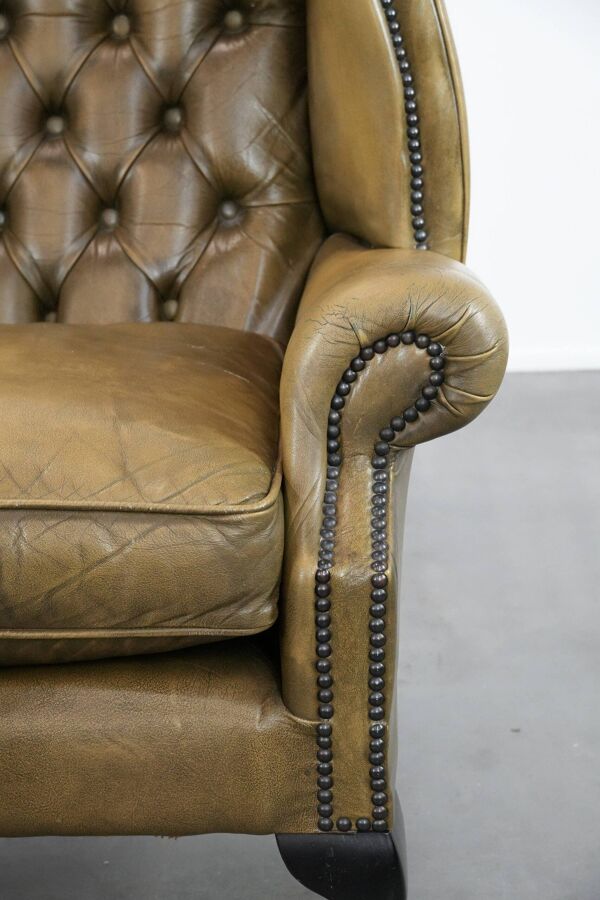 Fauteuil à oreilles Chesterfield en cuir vachette vert mousse de style anglais.