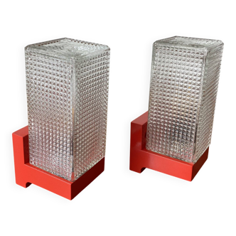 Pair of vintage wall lights in red plastic and clear glass.