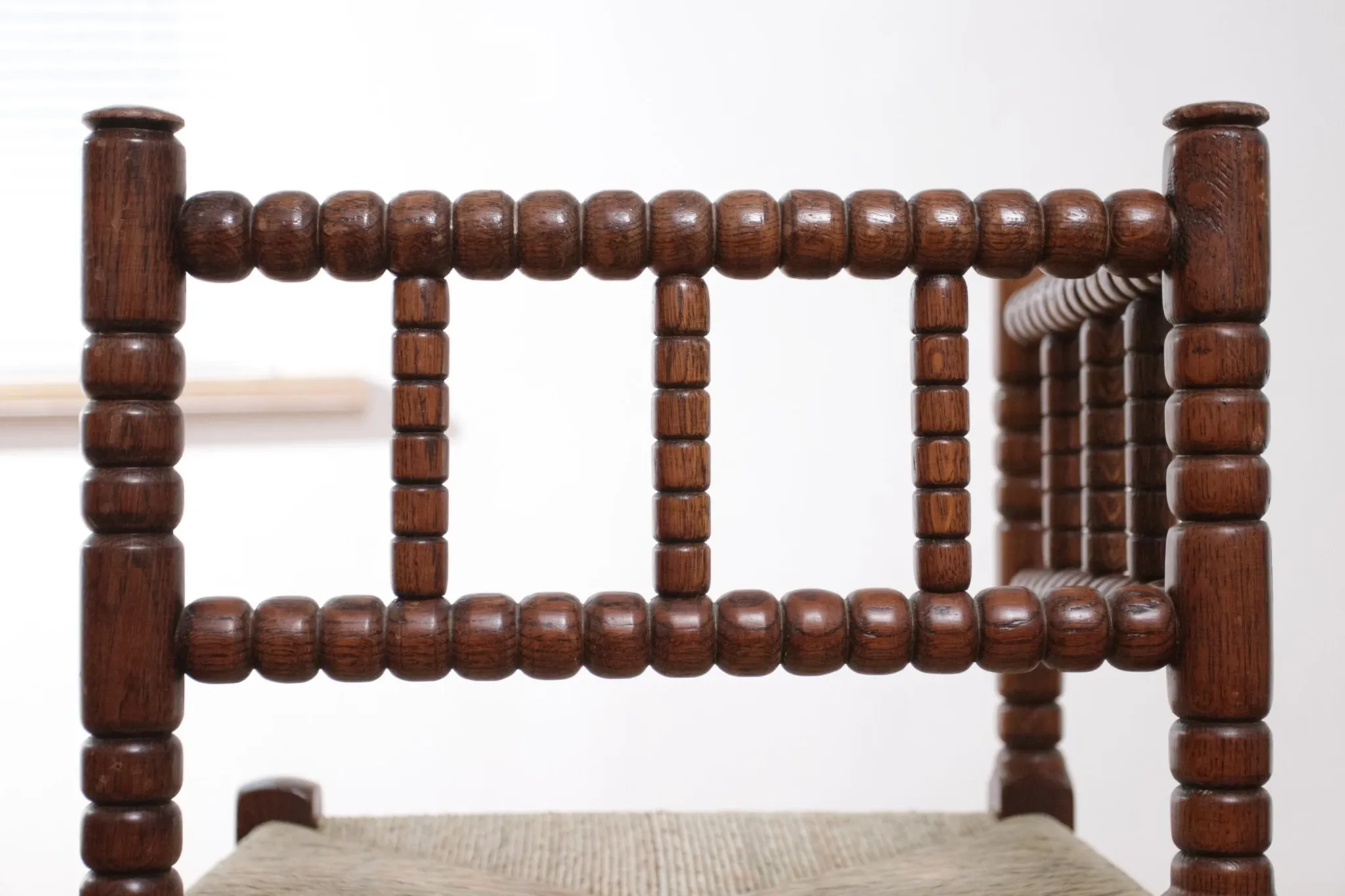 Antique Dutch oak corner chair with turned spindles and new rush seat