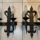 Pair of wrought iron wall lights in fleur-de-lis château style.