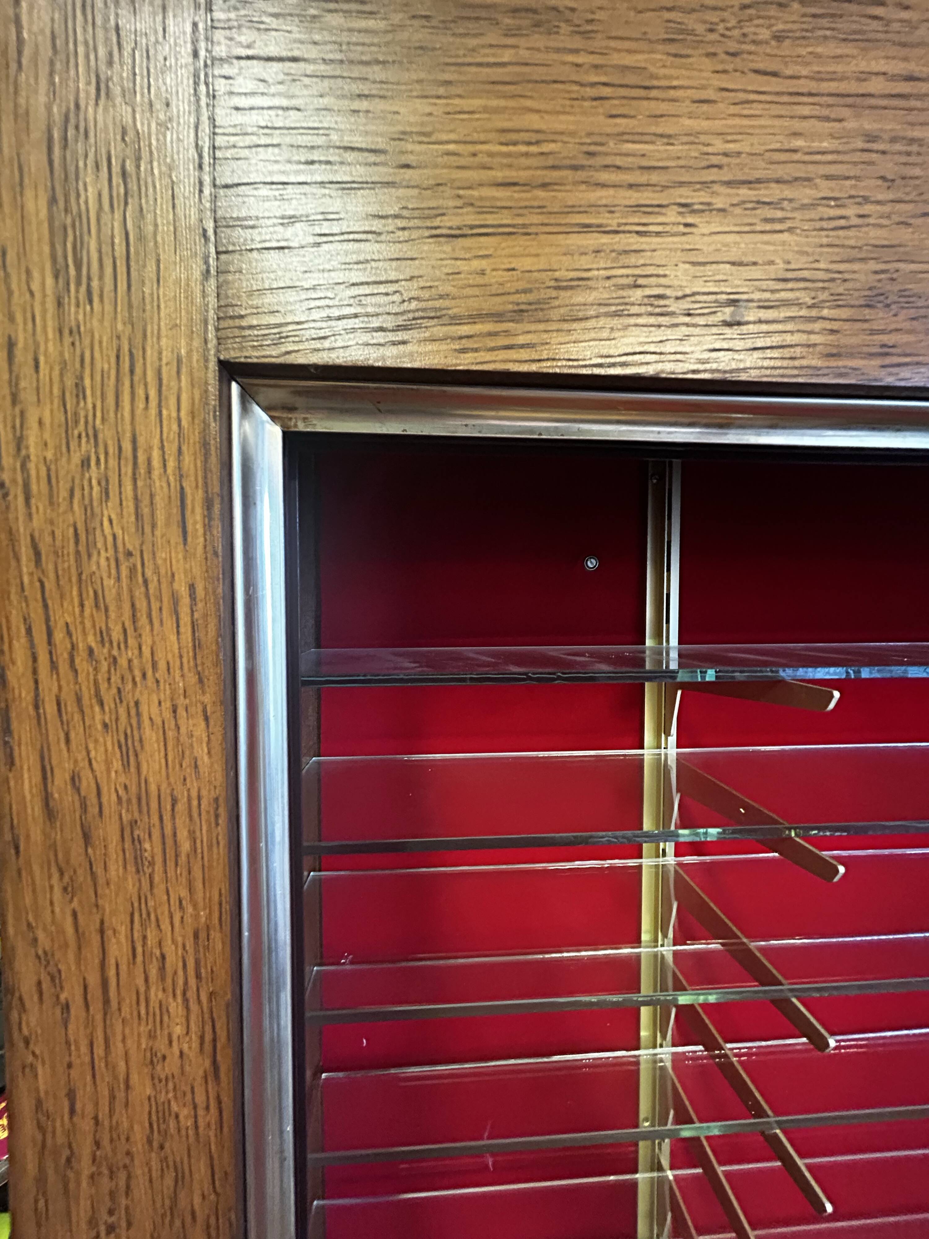 Large vintage display cabinet in wood and glass – red background, 15 shelves