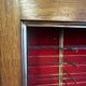 Large vintage display cabinet in wood and glass – red background, 15 shelves