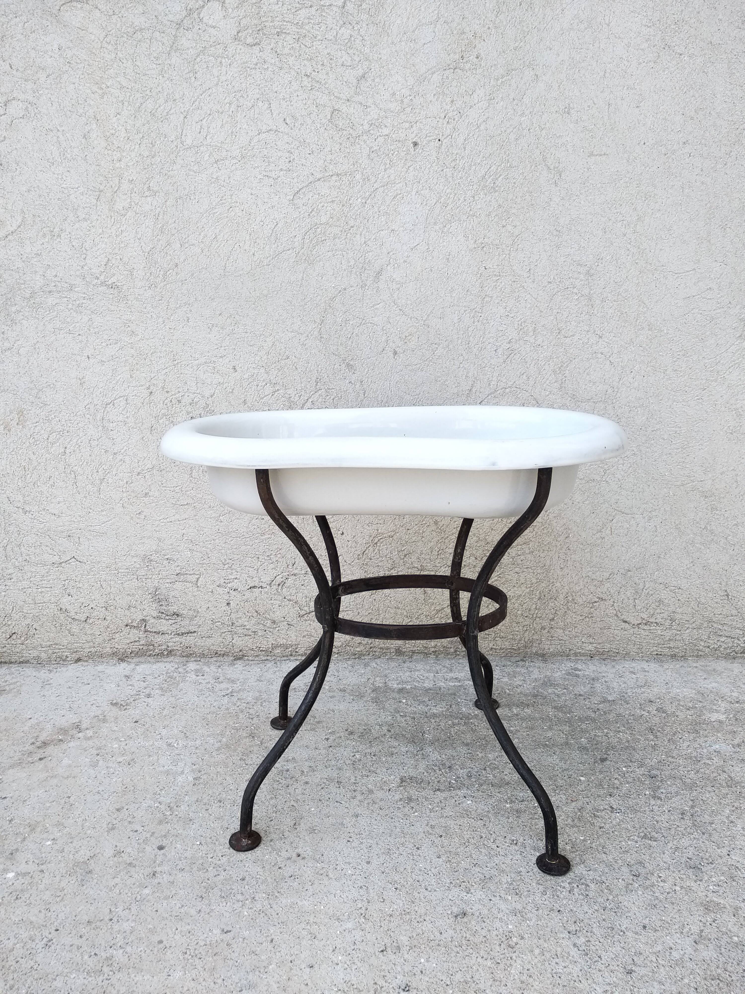 Antique bidet in enamelled sheet metal with wrought iron support