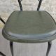 Black metal chairs with khaki faux leather seats, circa 1960.
