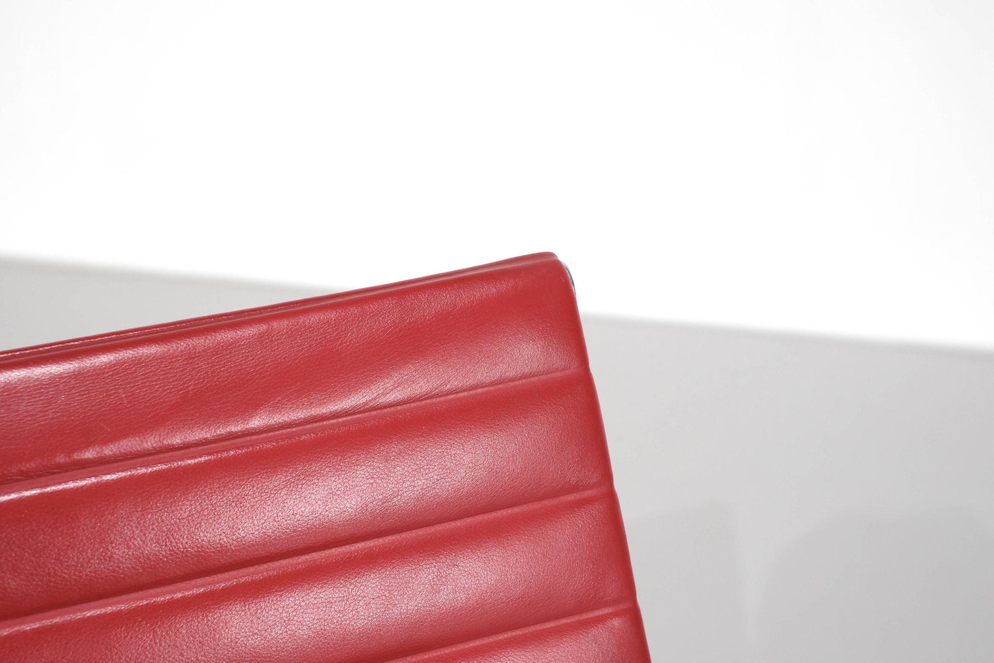 Fauteuil " EA 108 " en cuir rouge, conçu par Charles Ray Eames pour Vitra,