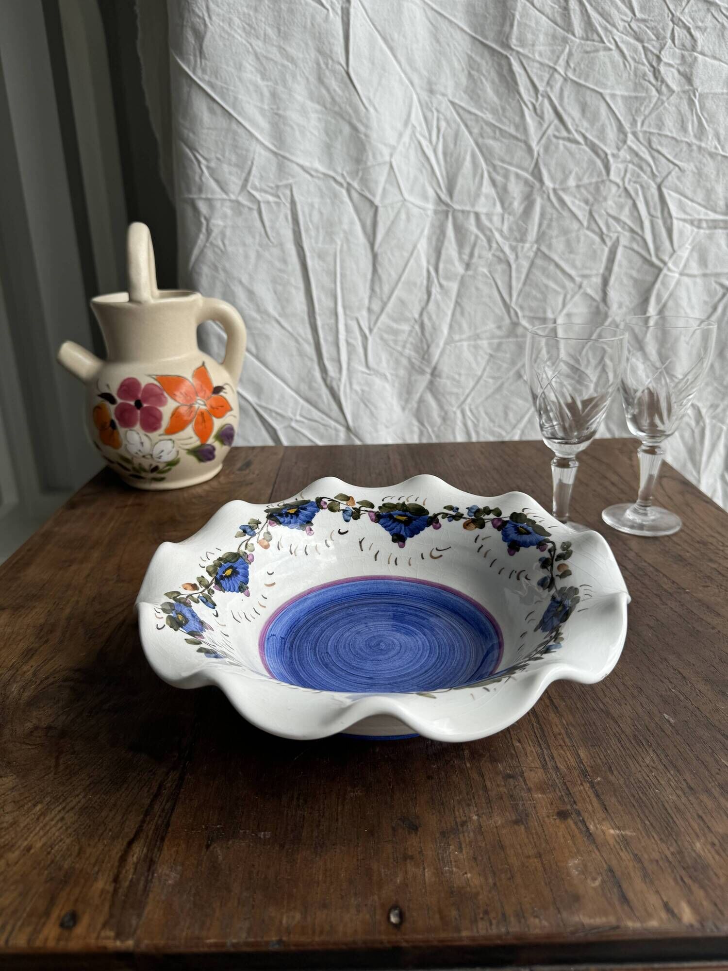 Small hand-painted earthenware salad bowl with garland of blue flowers, mark below