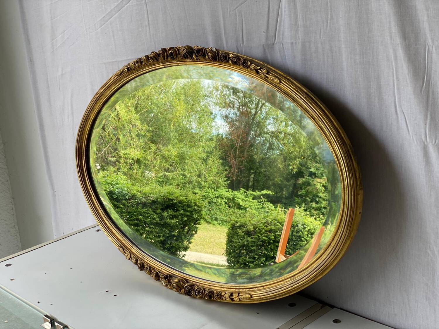 Vintage carved and gilded oval wall mirror