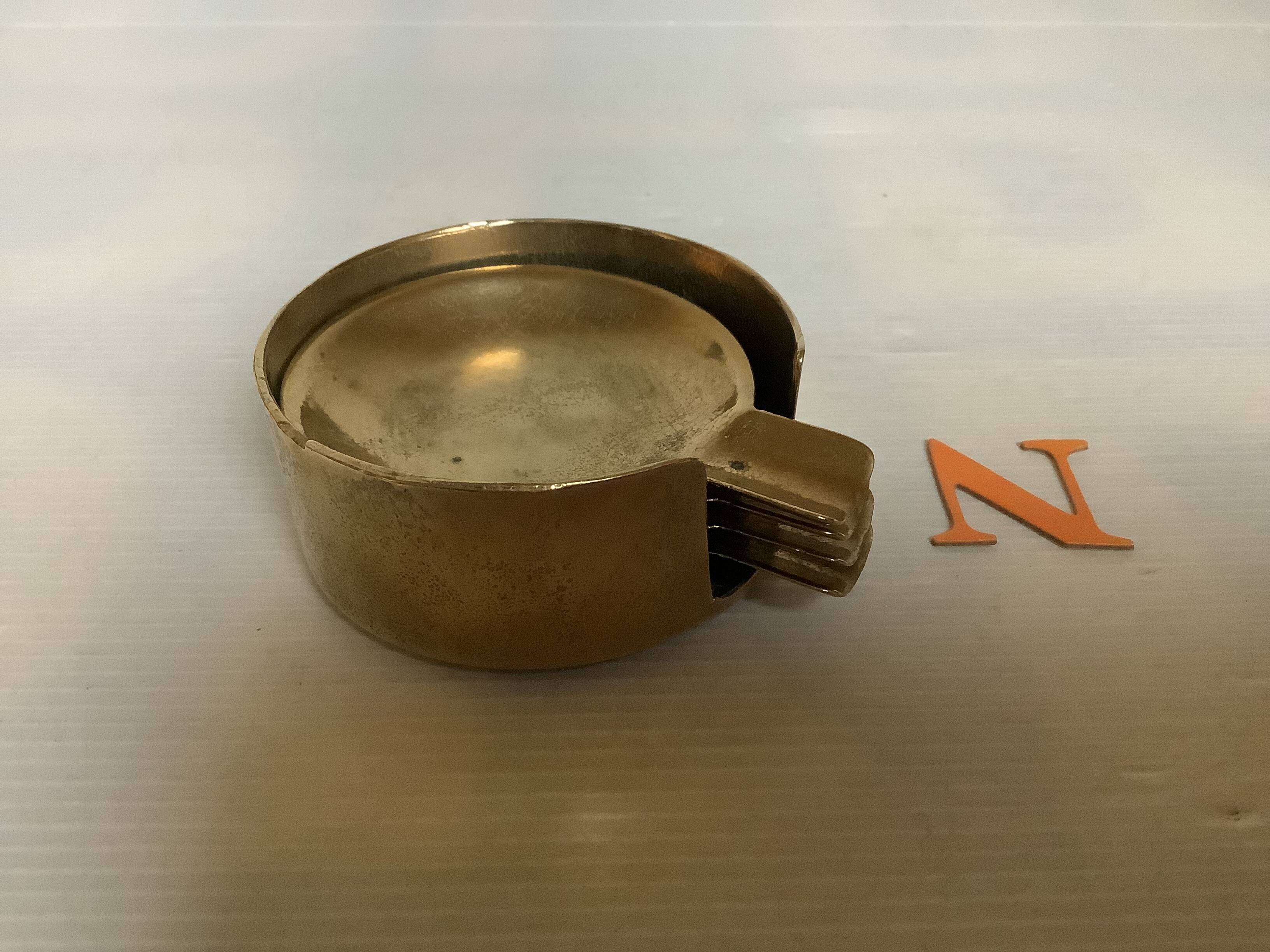 Four individual brass ashtrays