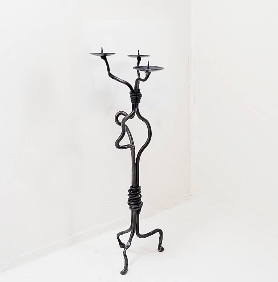 Large wrought iron candelabrum with an abstract design and three candle holders.