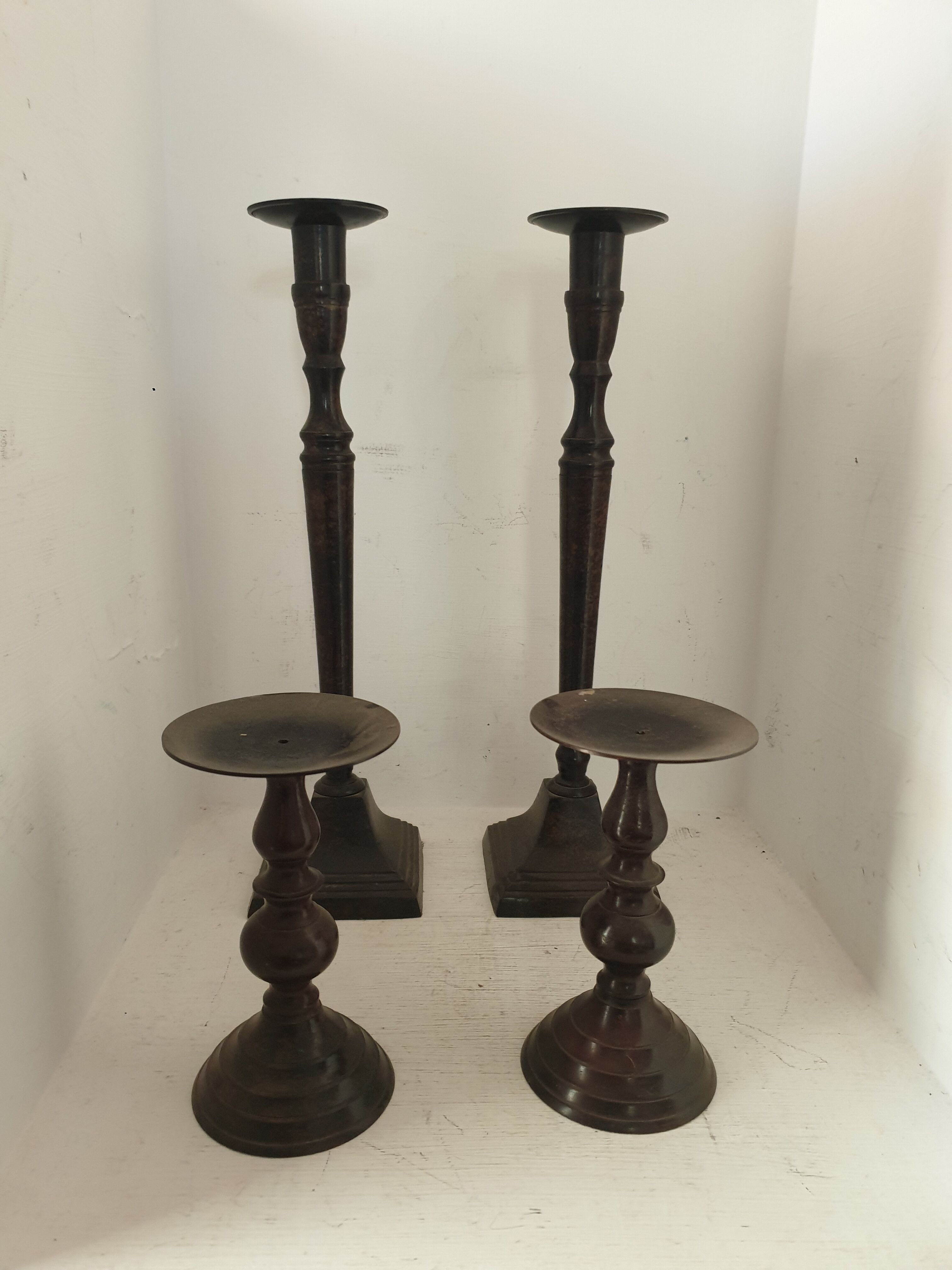 Two pairs of patinated brass candle holders