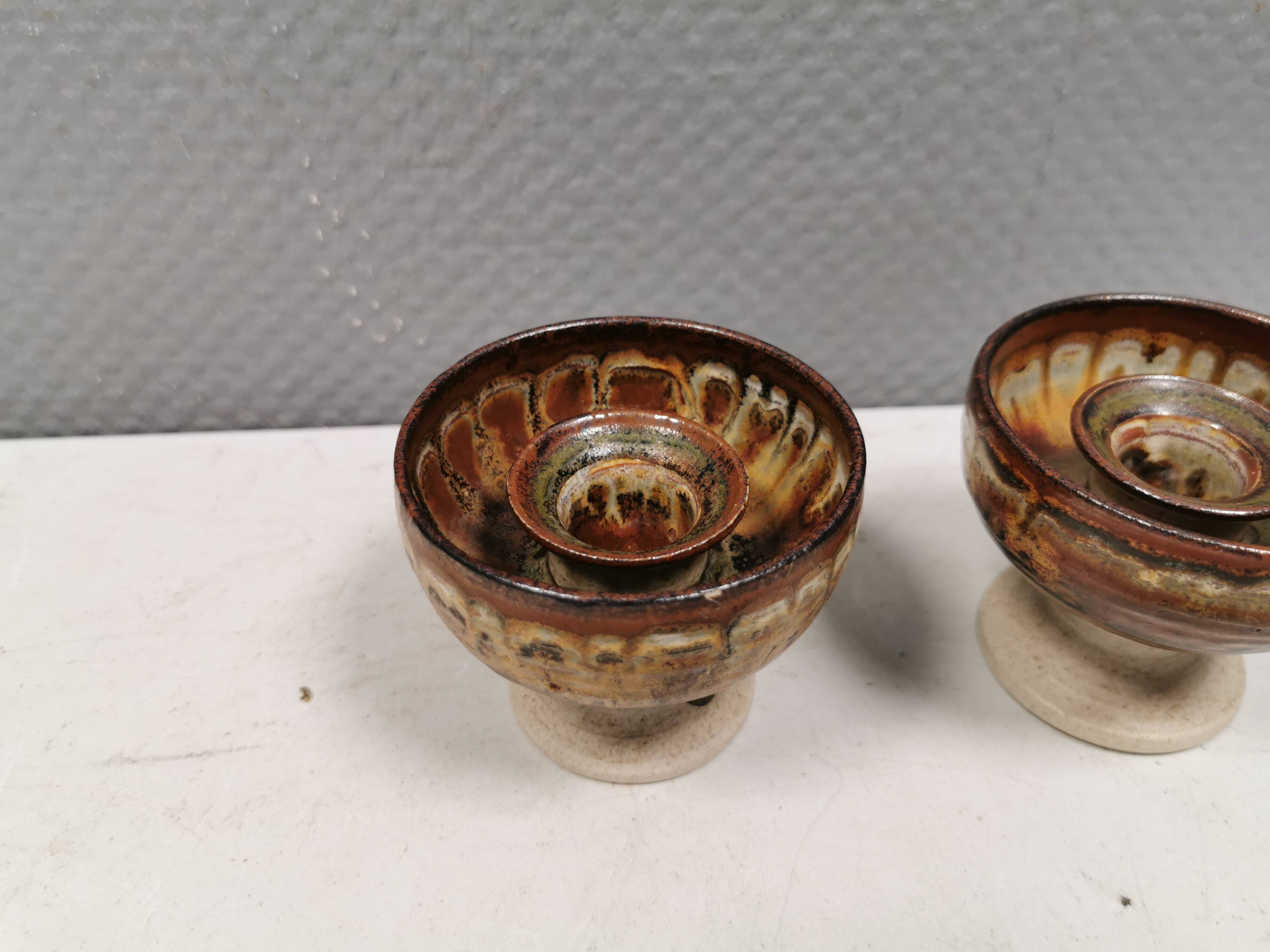 A set of ceramic candle holders in earthy colours.