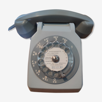 Ancien téléphone à cadran filaire vintage avec son écouteur, de couleur grise. Fin années 70 - début