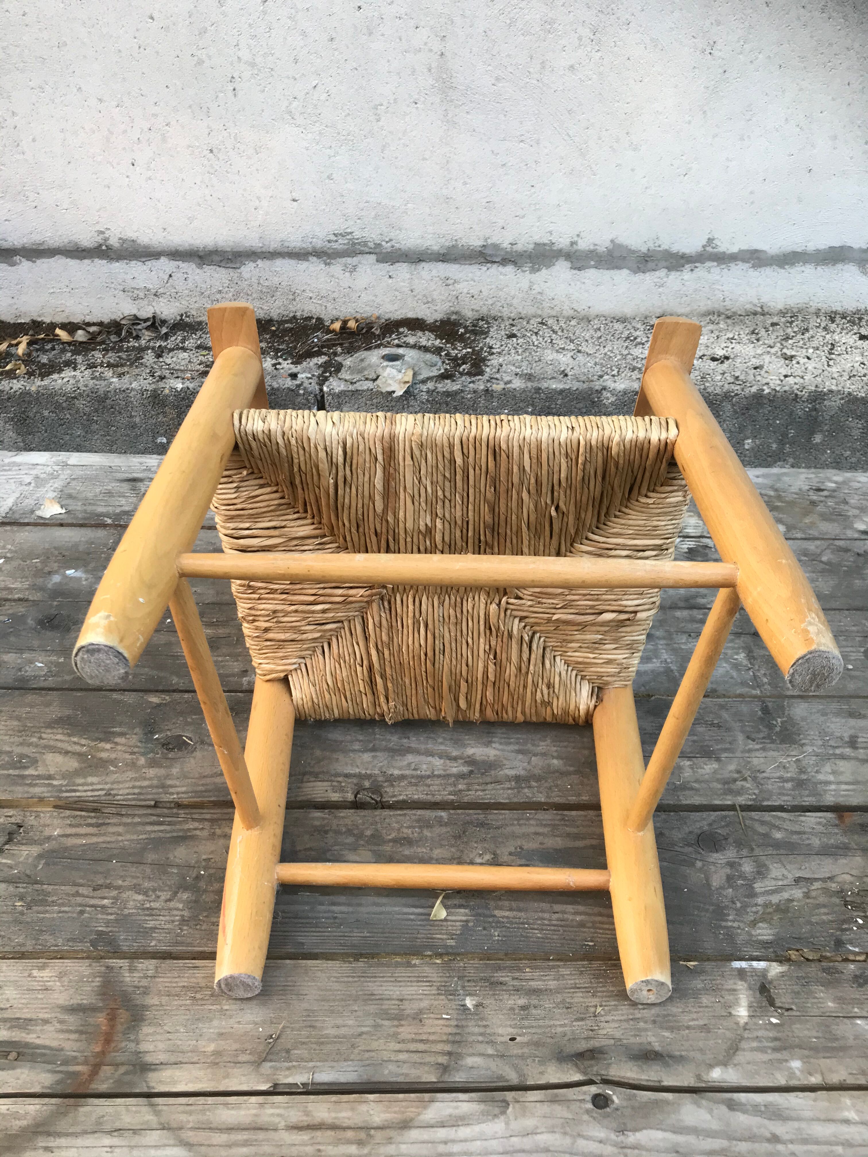 Old wooden children's armchair and vintage woven straw seat