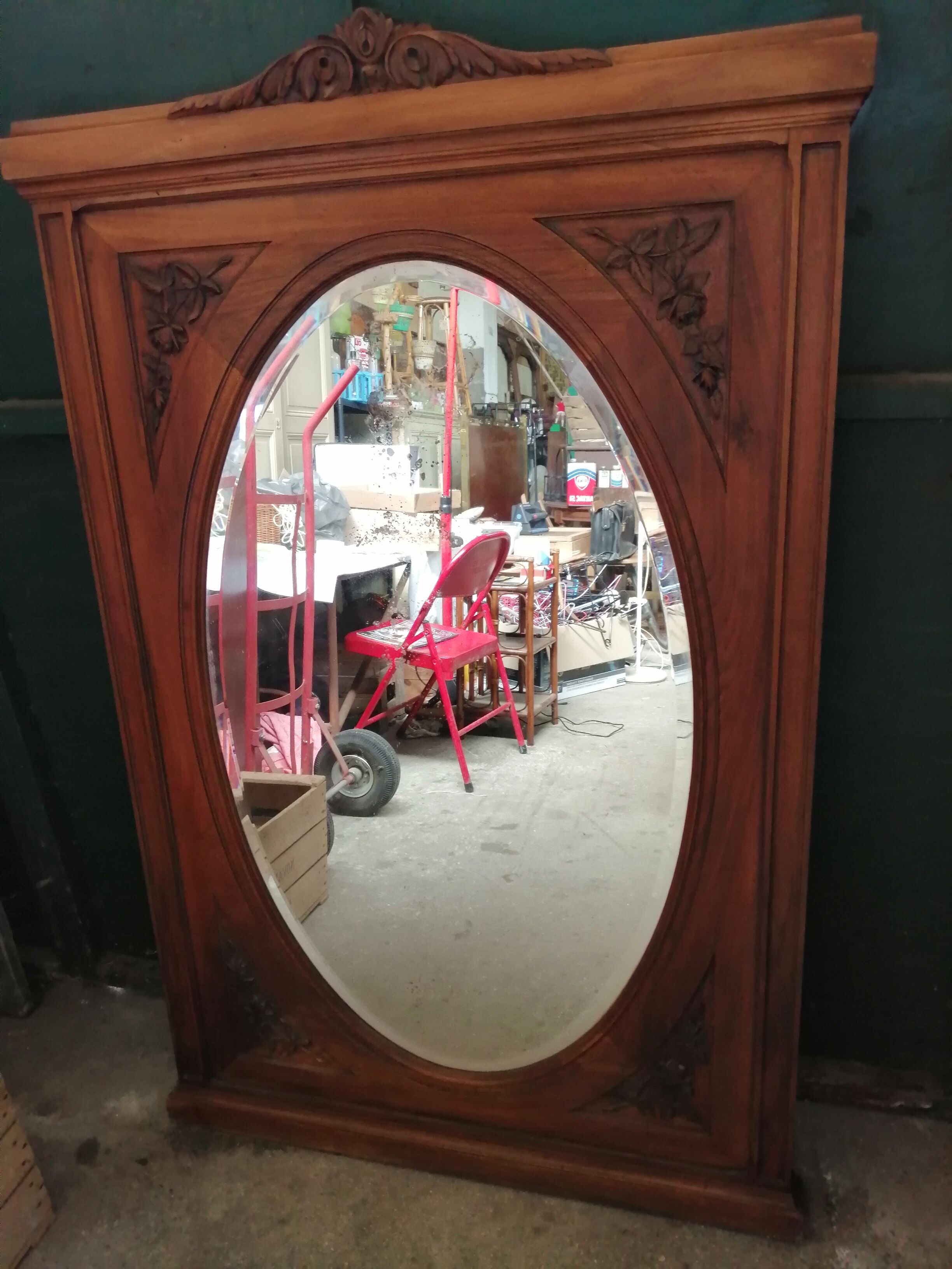 Old oval walnut wood mirror has flower carvings decoration