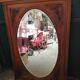 Old oval walnut wood mirror has flower carvings decoration
