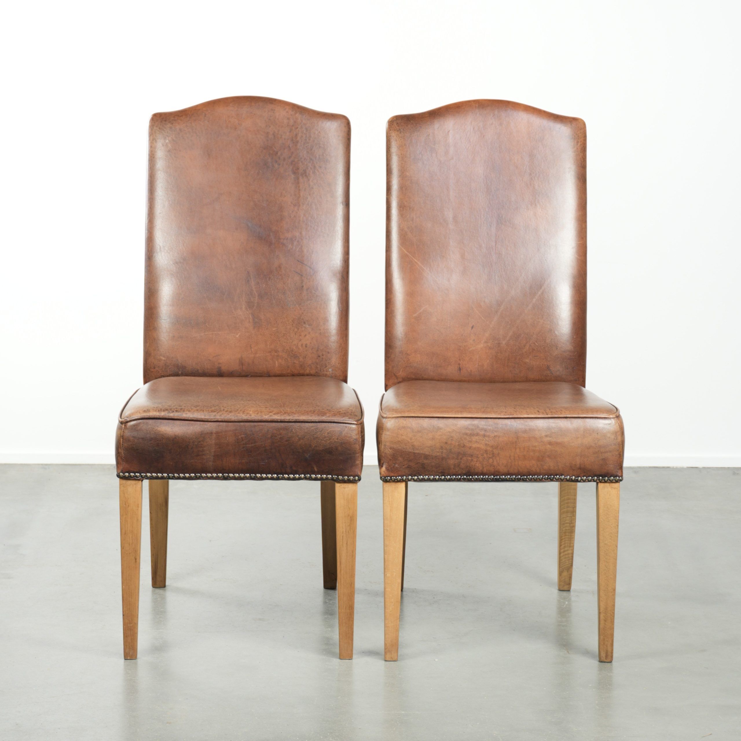 Set of 2 characterful dining chairs of sheepskin leather with a high back