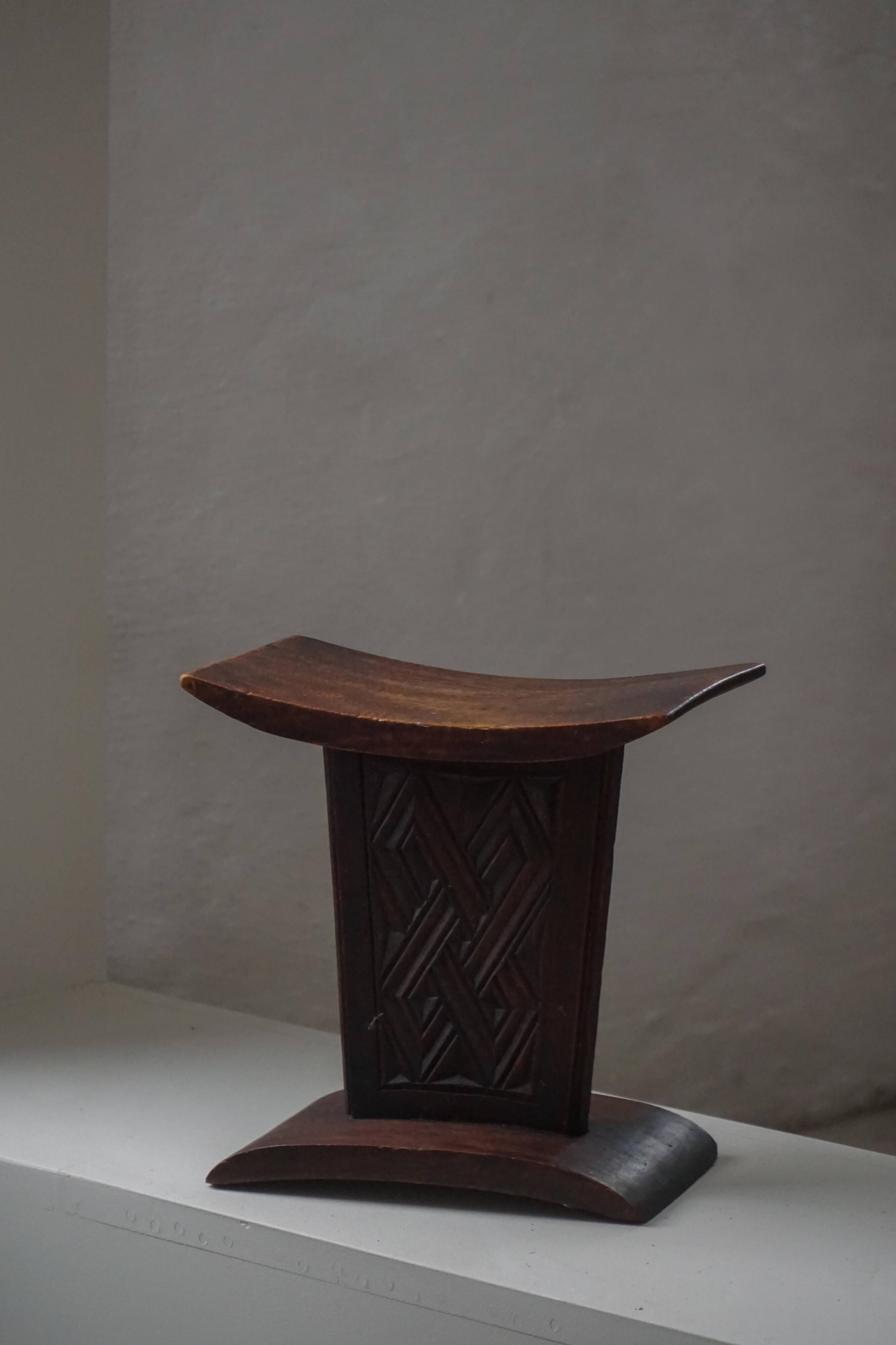 Sculptural African stool in hardwood, curved seat and architectural base, 1970s.
