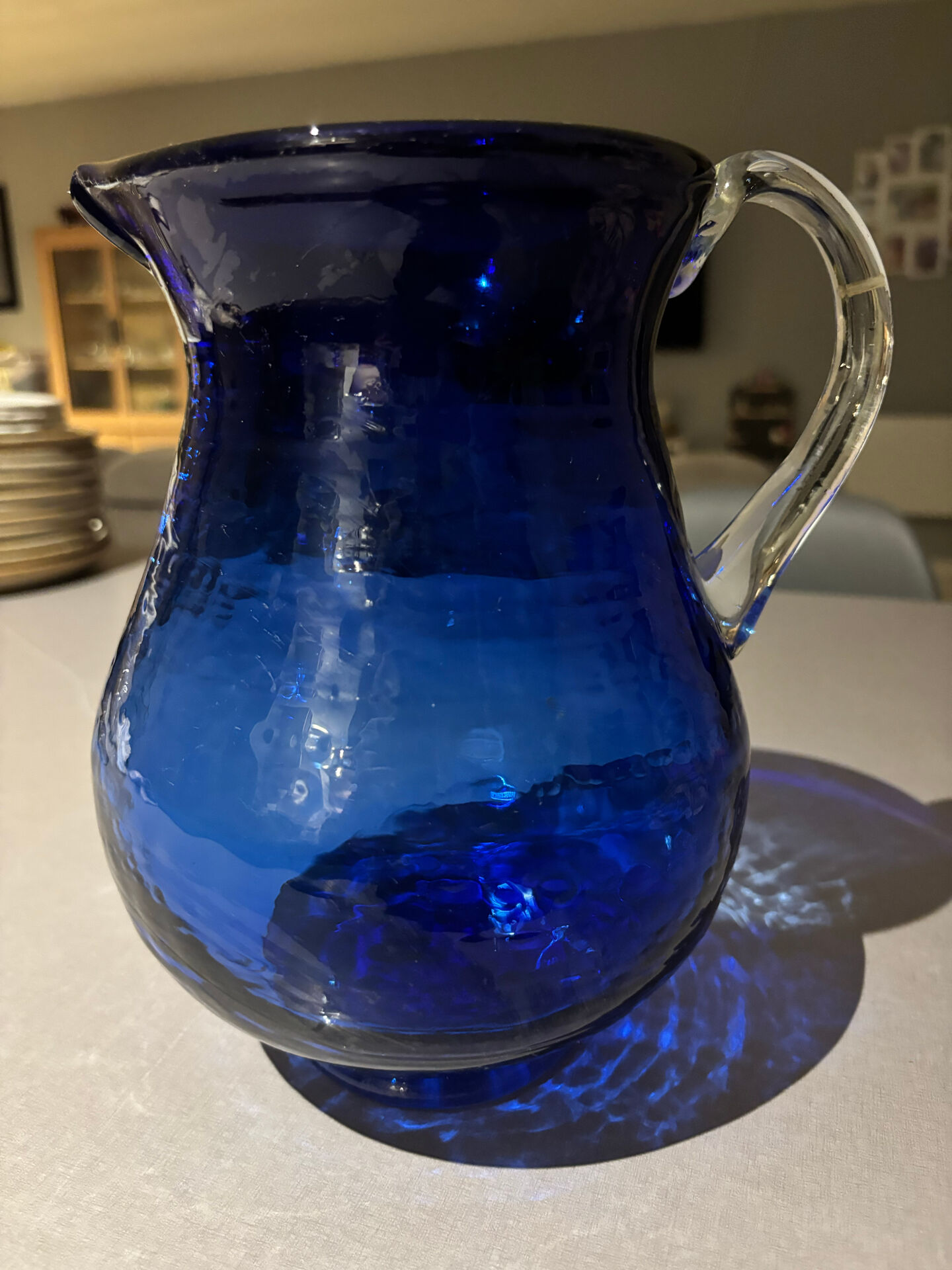 Vintage cobalt blue blown glass jug with a transparent handle.