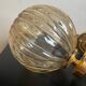 Brass wall light and bubbled glass globe