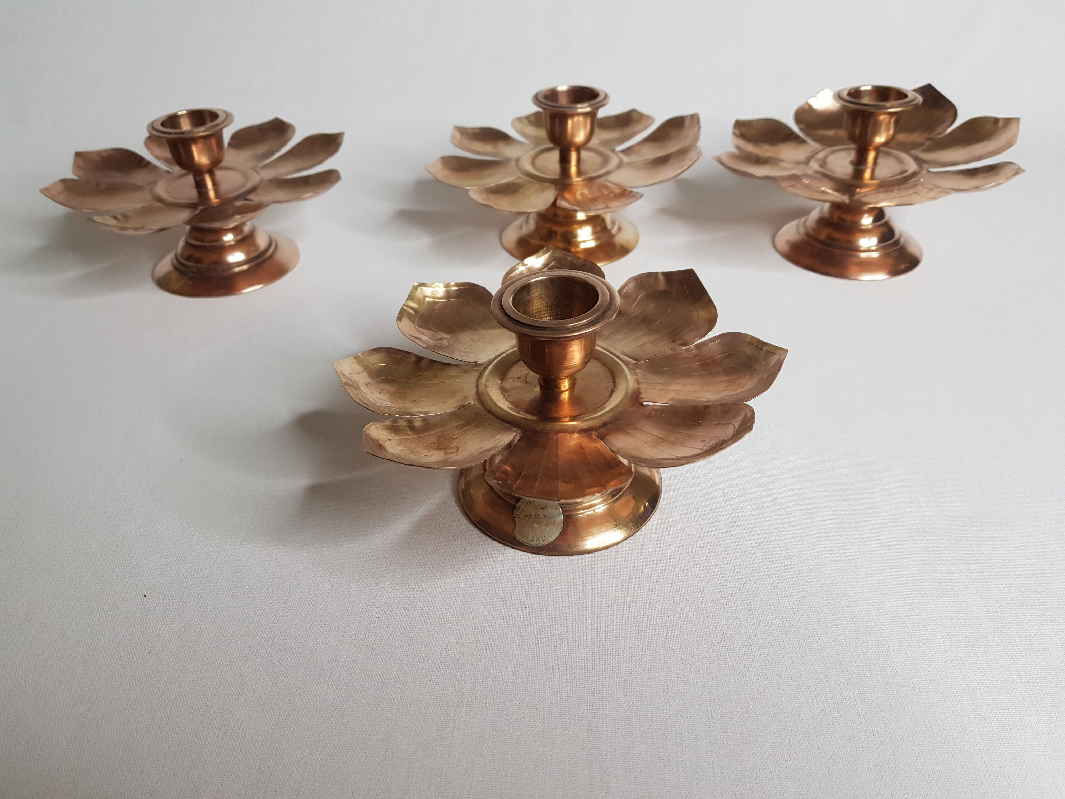 Set of four copper candlesticks in the shape of lotus flowers