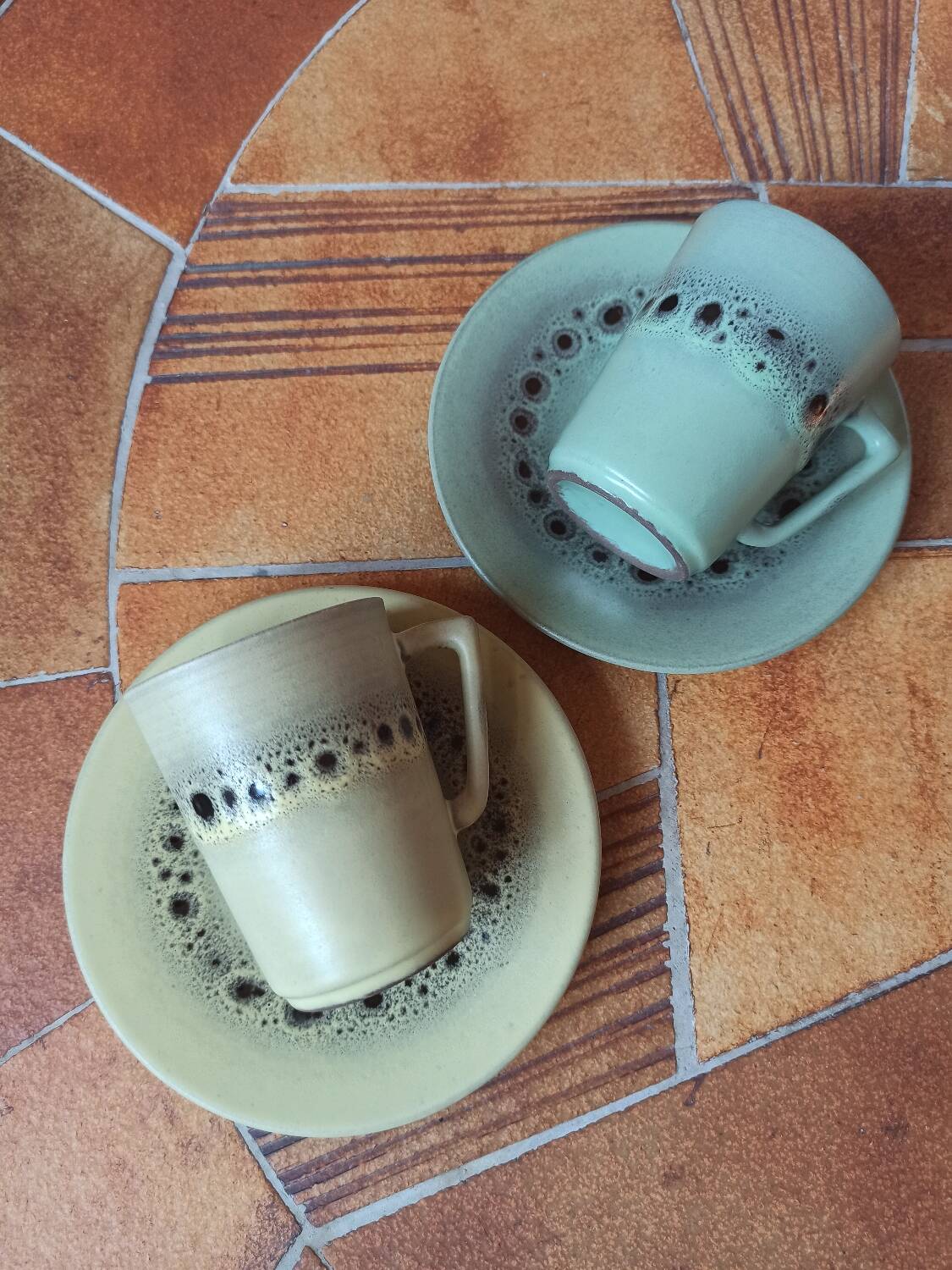 A pair of vintage glazed stoneware cups and saucers.