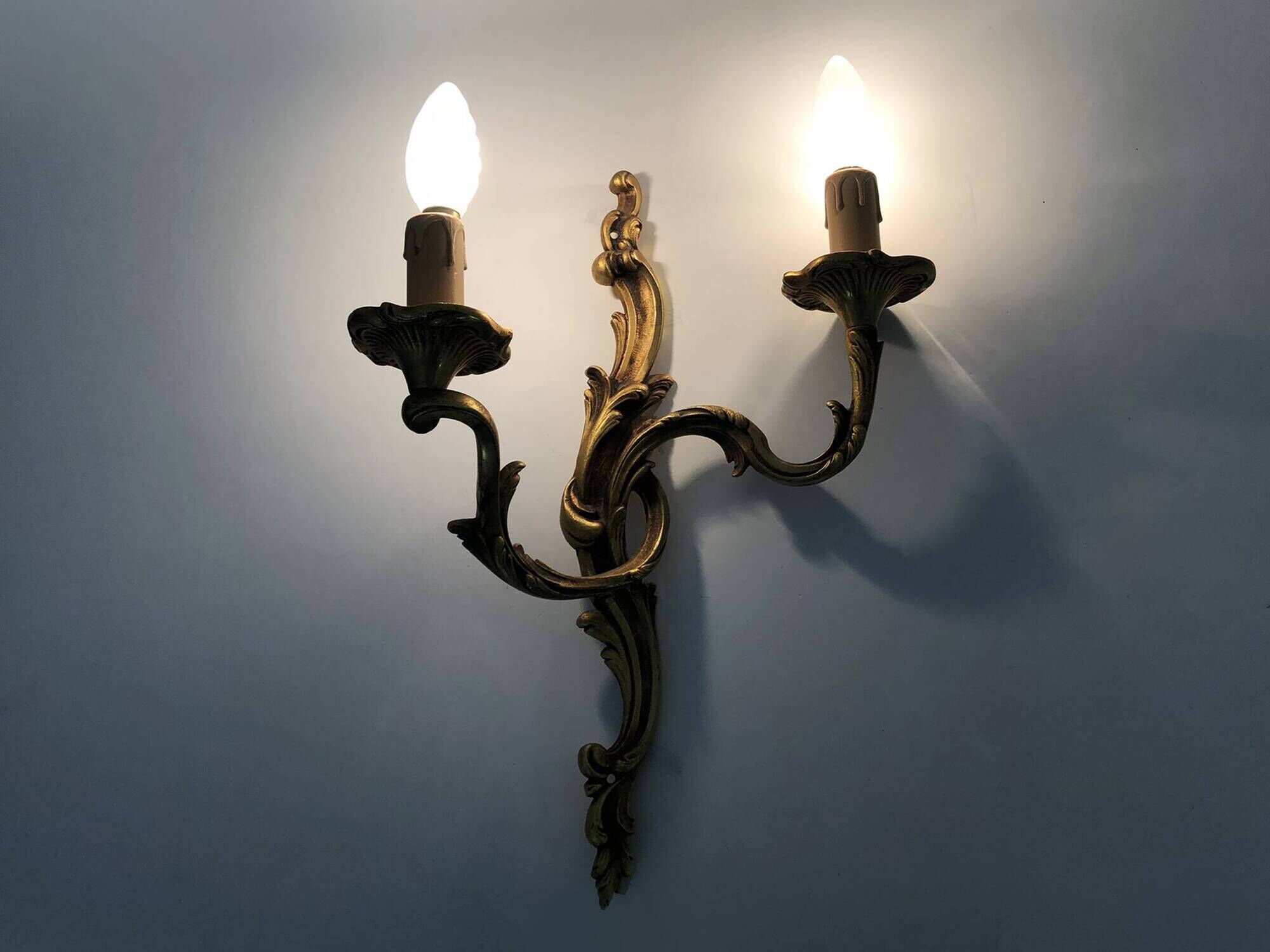 Antique pair of double-light bronze wall sconces with acanthus leaves. 1950s