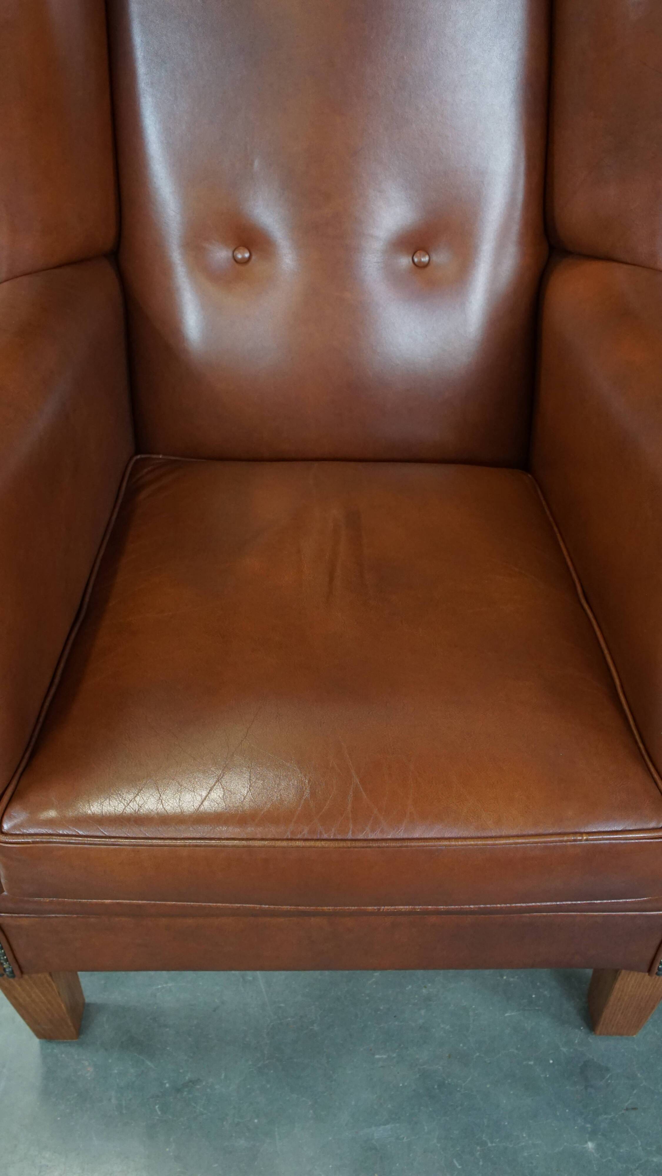 Cognac-colored leather wingback chair in English style