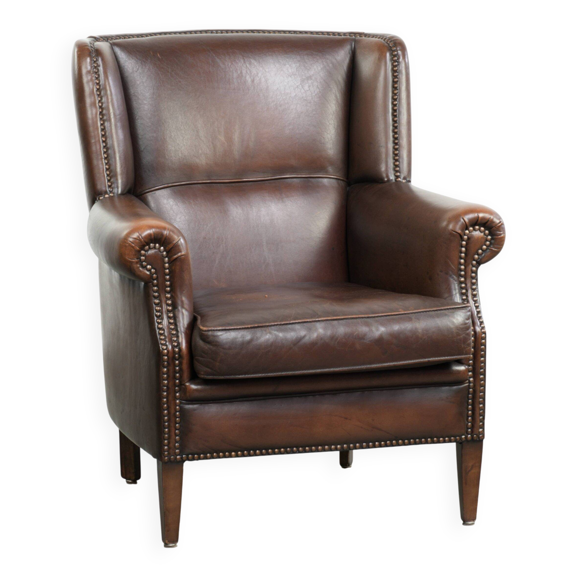 Subtle sheepskin wingback armchair with a deep cognac colour