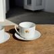 Pair of white porcelain cups from ADP France with a floral pattern and their s