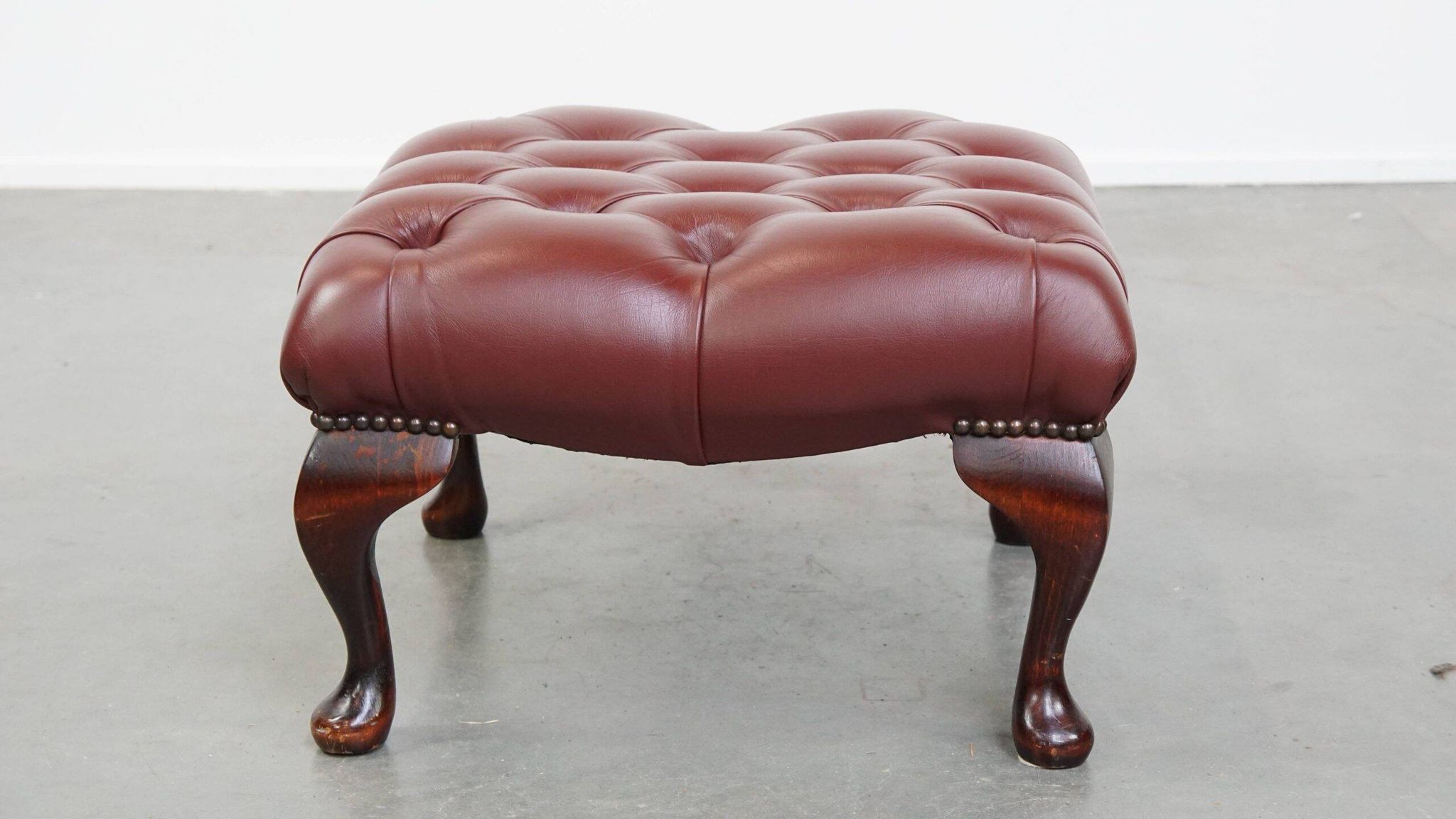 In very good condition elegant red/brown chesterfield ottoman made of cow leather