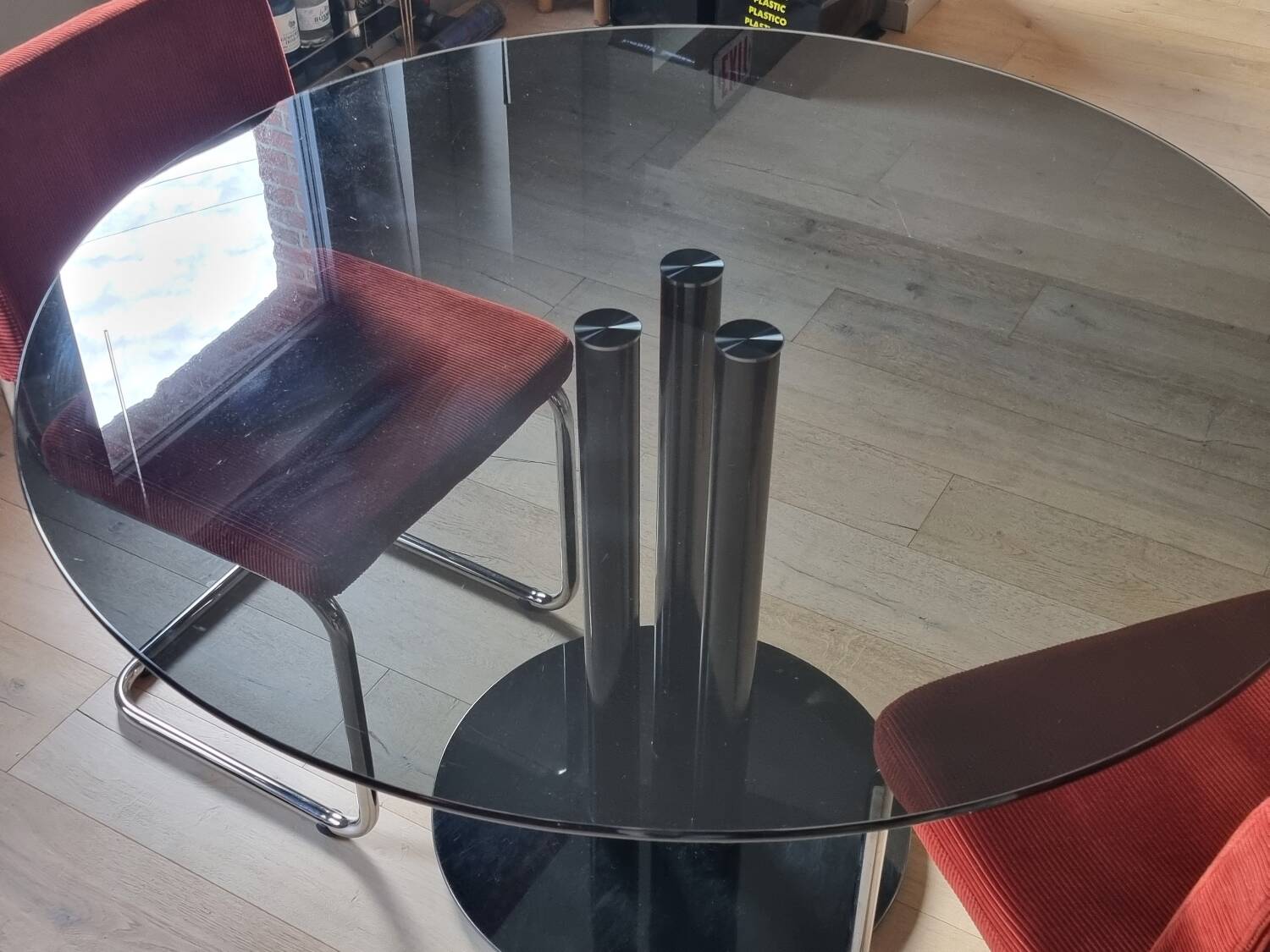 Round black smoked glass dining table + 2 terracotta chairs