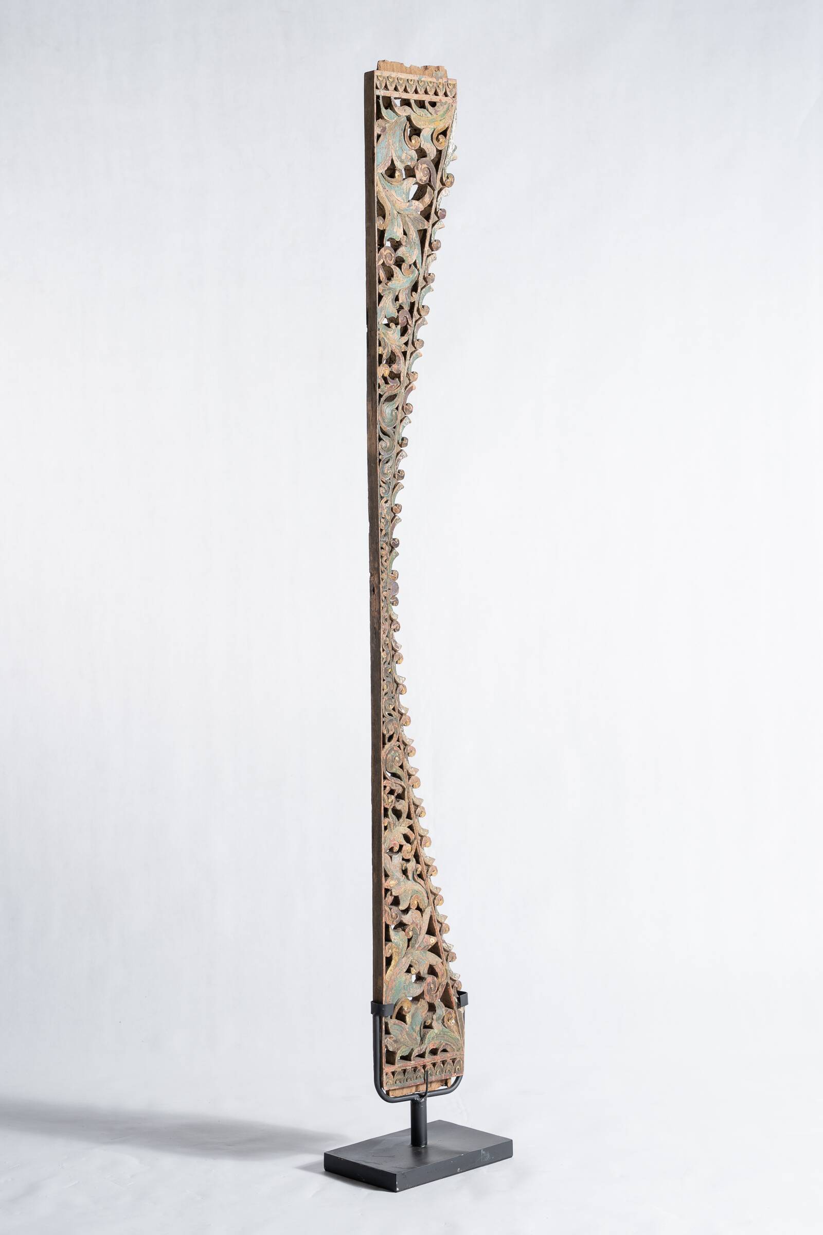 Indonesian construction element in carved wood with intertwined plant motifs mounted on a base (fri