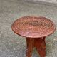 Round folding side table made of carved solid wood.