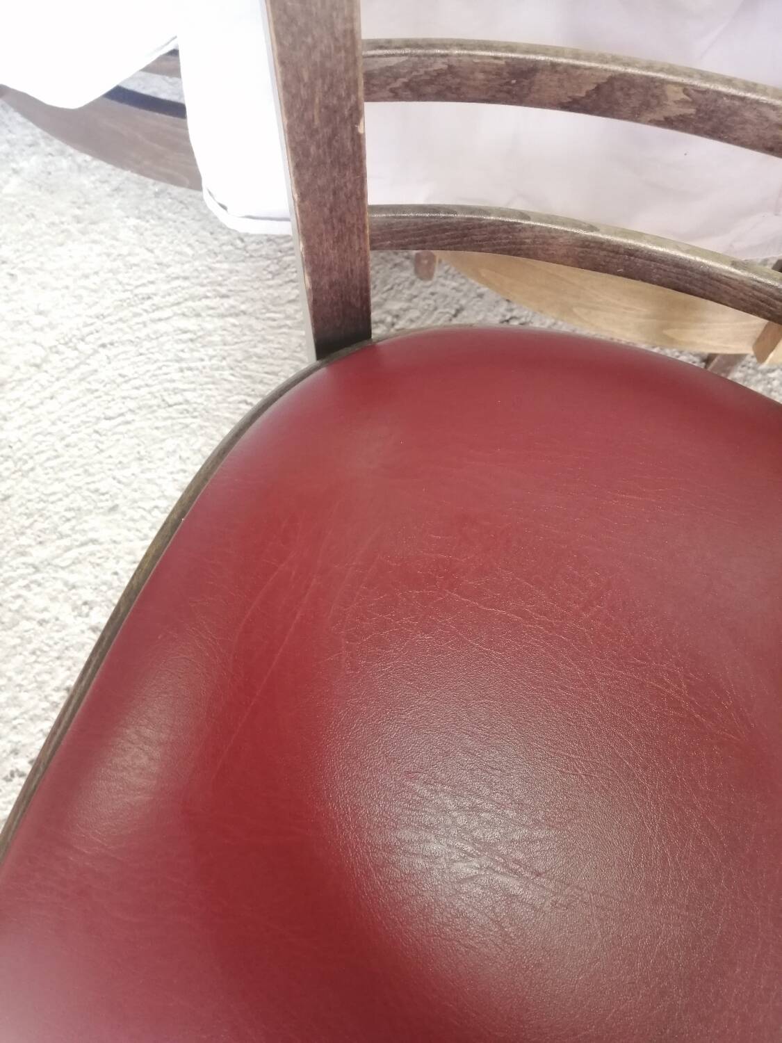 Set of 19 vintage wooden bistro chairs with red faux leather.