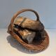 Woven Rattan Log Holder in a Semi-Round Shape with a Central Arched Handle.