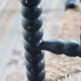 Antique black turned wood corner chair with a straw seat.