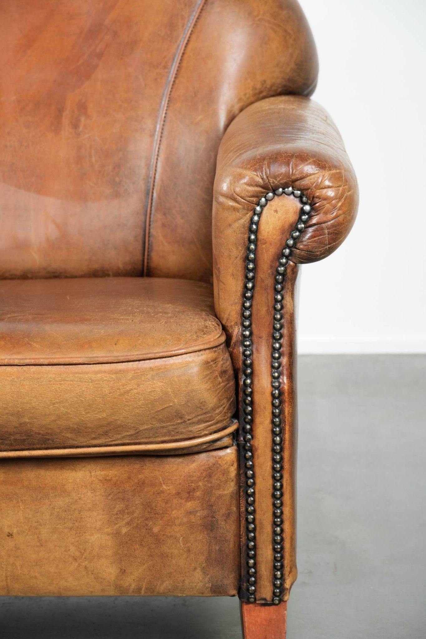 Sheepskin armchair with a beautiful vintage look and decorative nail finish