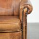 Sheepskin armchair with a beautiful vintage look and decorative nail finish