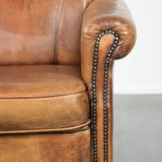 Sheepskin armchair with a beautiful vintage look and decorative nail finish