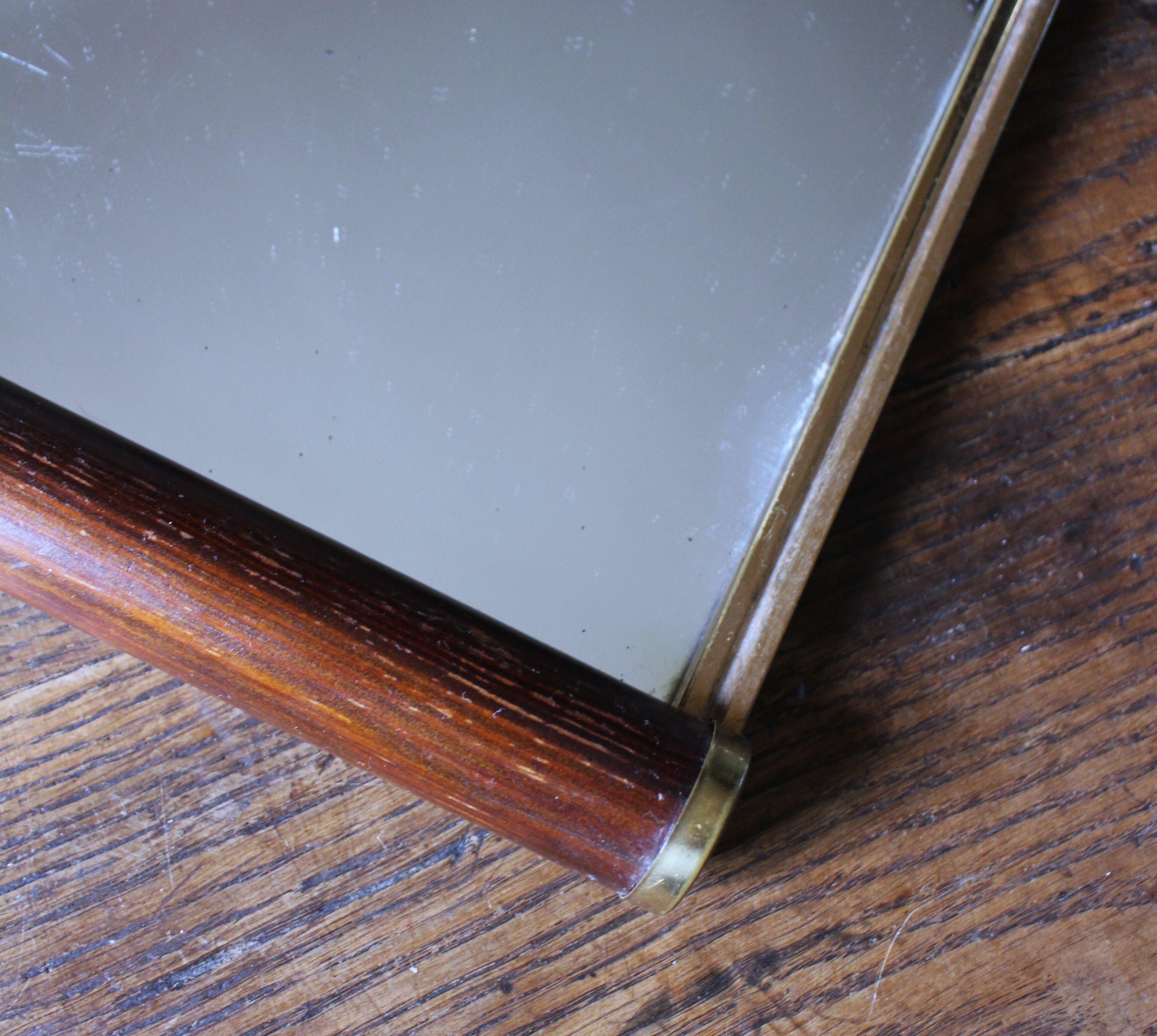 Rectangular mirror tray with wooden handles and gilding.