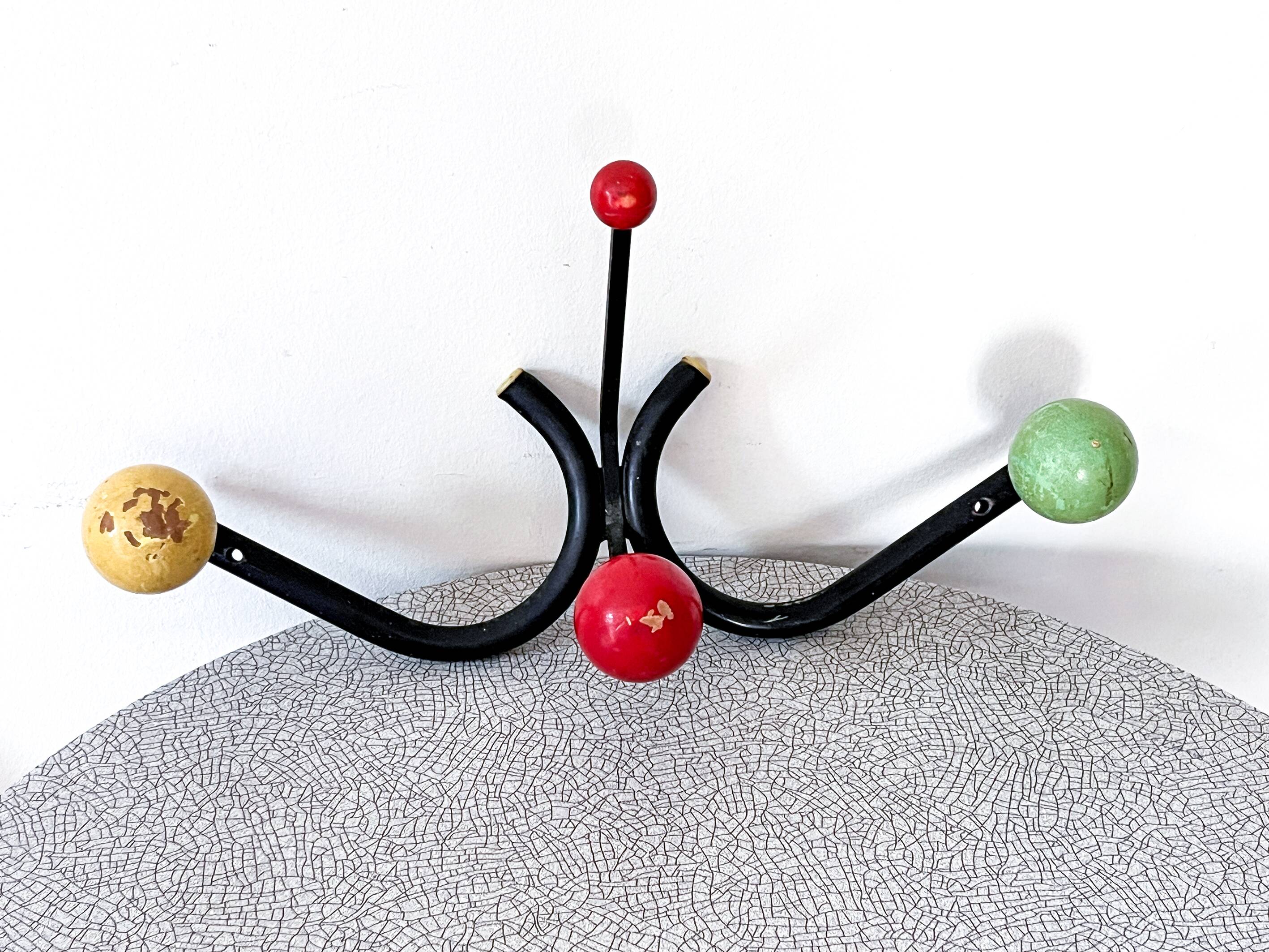 Vintage metal and wood coat rack in yellow/red/green.